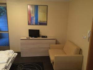 a room with a chair and a desk with a television at Apartman Harrachov in Harrachov