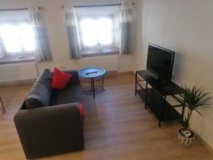 a living room with a couch and a flat screen tv at Haus Monteiro in Elbigenalp