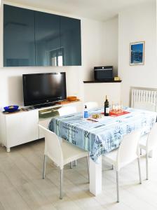 d'une salle à manger avec une table, des chaises et une télévision. dans l'établissement CONERO APARTMENT, à Castelfidardo