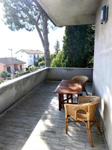 a patio with a wooden table and chairs on a wall at CONERO APARTMENT in Castelfidardo