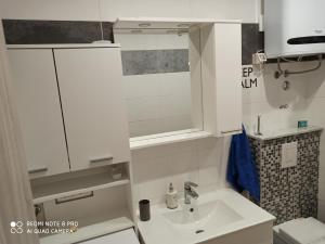 a white bathroom with a sink and a mirror at Odyssey apartment in Split