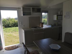 a kitchen with a stove and a table and a window at Nature Monchy in Campneuseville