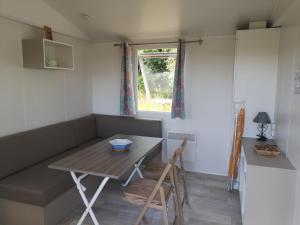 - une table et des chaises dans une petite chambre avec fenêtre dans l'établissement Nature Monchy, à Campneuseville
