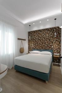 a bedroom with a bed and a brick wall at Hora Seaside Suites in Naxos Chora