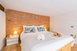 sypialnia z dużym białym łóżkiem z ceglaną ścianą w obiekcie LUI Tuscany Loft w mieście San Miniato