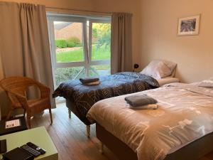 2 camas en una habitación con ventana en B&B Molen Ter Walle, en Geraardsbergen