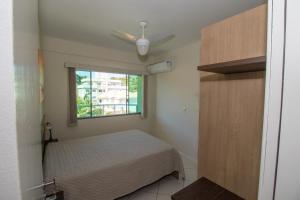 1 dormitorio con cama y ventana en Res Calliandra Apto 102, en Bombinhas