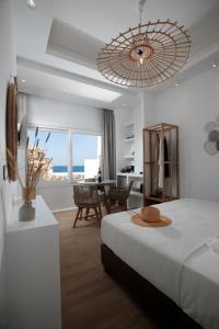 a bedroom with a large bed and a dining room at Hora Seaside Suites in Naxos Chora
