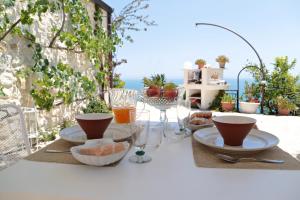 - une table avec des assiettes de nourriture et des verres à vin dans l'établissement Punta Palivi, à Mattinata