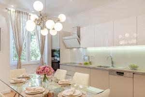a kitchen with a glass table and white cabinets at BELAMAR LUXURY APARTMENT SPLIT in Split