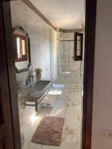 een witte badkamer met een wastafel en een douche bij B&B L'Orologio in Signa