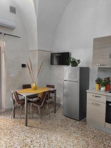 una cucina con tavolo, sedie e frigorifero di House Serena a Galatone
