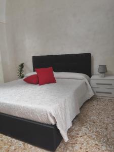 una camera con letto nero e cuscino rosso di House Serena a Galatone