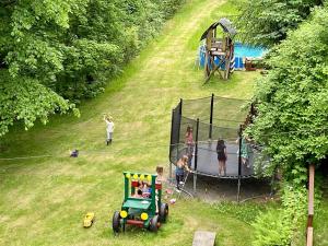 a group of children playing in a playground with a toy tractor at Chalupa U Potoka in Josefŭv Dŭl