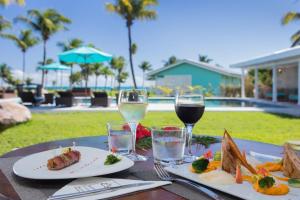 una tavola con piatti di cibo e bicchieri di vino di Raiatea Lodge Hotel a aUturoa