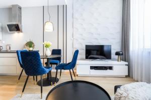 salon ze stołem i niebieskimi krzesłami w obiekcie Wielopole17 Max Apartment with AC w Krakowie