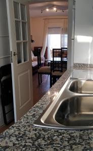 eine Küche mit einem Waschbecken und ein Wohnzimmer in der Unterkunft Albatros Golf Costa Esuri Ayamonte Huelva in Ayamonte