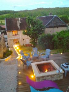 un patio con sillas y una hoguera con luces en Chez Petit, en Argançon
