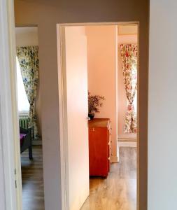 - un couloir avec une porte menant à une chambre dotée de fenêtres dans l'établissement Chez Petit, à Argançon