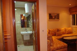 ein Bad mit einem Waschbecken und einem Sofa in einem Zimmer in der Unterkunft Résidence Ifrane Palace in Ifrane