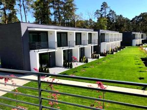 a building with a green lawn in front of it at BOHO MARE Apartament Pobierowo in Pobierowo