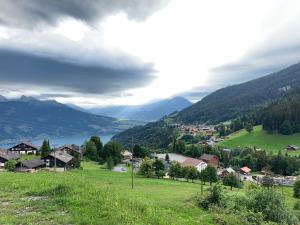 a village in a valley with a lake and mountains at Self- Check- In Hotel Regina Beatenberg in Beatenberg