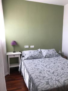 a bedroom with a bed and a table with a lamp at Atiko 15 in Gijón
