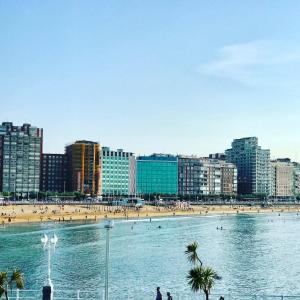 a view of a beach with people and buildings at Atiko 15 in Gijón