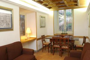uma sala de jantar com mesa, cadeiras e janelas em Villino Corbelli B&B em Roma