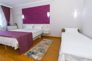 a room with two beds and a purple window at Vila Cataleya in Venus