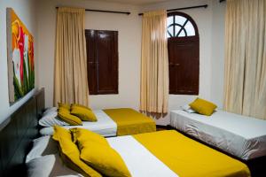 um quarto com 2 camas e almofadas amarelas em Casabella Hotel em Manizales mais 12 fotografias
