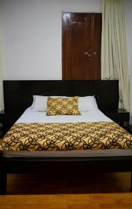 uma cama com uma cabeceira preta e uma almofada em Casabella Hotel em Manizales