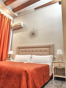 um quarto com uma cama grande e um cobertor laranja em Hostal Orleans em Barcelona