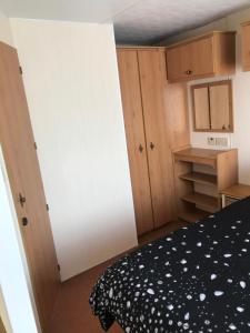 a small bedroom with a bed and a mirror at Caravan to Hire Dymchurch in Dymchurch