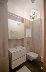 a bathroom with a sink and a toilet and a chandelier at BLISS Apartment in Constanţa +22 photos