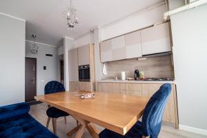 a kitchen and dining room with a wooden table and chairs at BLISS Apartment in Constanţa