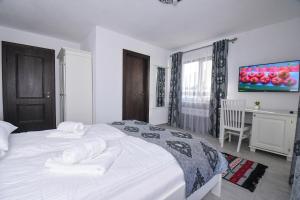 a bedroom with a white bed with towels on it at Casa Alexandru – Locul în care te simți acasă in Vişeu de Jos