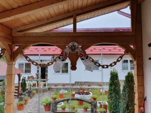 a wooden pergola with a chandelier in a garden at Casa Alexandru – Locul în care te simți acasă in Vişeu de Jos