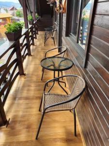 a row of tables and chairs on a porch at Casa Alexandru – Locul în care te simți acasă in Vişeu de Jos