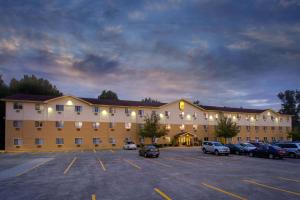 ein großes Gebäude mit Autos auf einem Parkplatz in der Unterkunft Super 8 by Wyndham Cromwell/Middletown in Cromwell