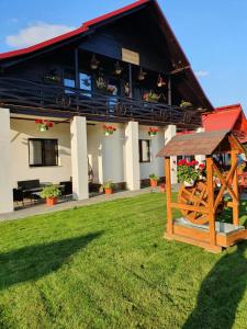 a house with a gambrel roof with a gazebo at Casa Alexandru – Locul în care te simți acasă in Vişeu de Jos