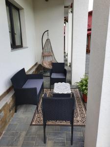a patio with chairs and a table and a swing at Casa Alexandru – Locul în care te simți acasă in Vişeu de Jos