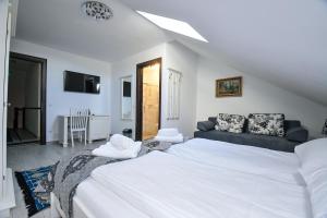a bedroom with a large white bed and a couch at Casa Alexandru – Locul în care te simți acasă in Vişeu de Jos