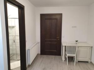a room with a door and a table and a chair at Casa Alexandru – Locul în care te simți acasă in Vişeu de Jos