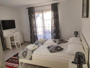 a bedroom with a large white bed with a window at Casa Alexandru – Locul în care te simți acasă in Vişeu de Jos