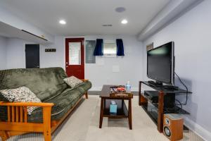 a living room with a couch and a flat screen tv at English Basement Suite in Petworth, Washington, DC -- FREE off-street parking, walk to Metro and restaurants in Washington