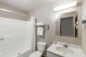 a bathroom with a toilet and a sink and a mirror at Super 8 by Wyndham Hays KS in Hays