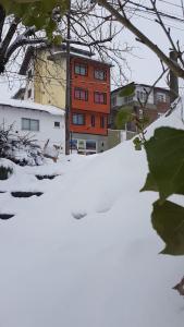 un cumulo di neve di fronte a un edificio di Hospedaje Lo de Max a San Carlos de Bariloche