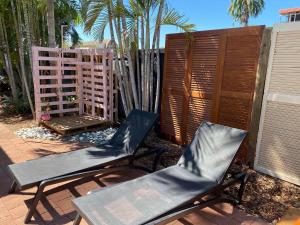 two chairs and a table on a patio at Darwin Hostel in Darwin