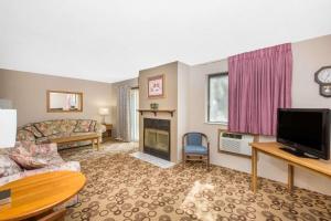 a living room with a television and a fireplace at Super 8 by Wyndham Blue Earth in Blue Earth